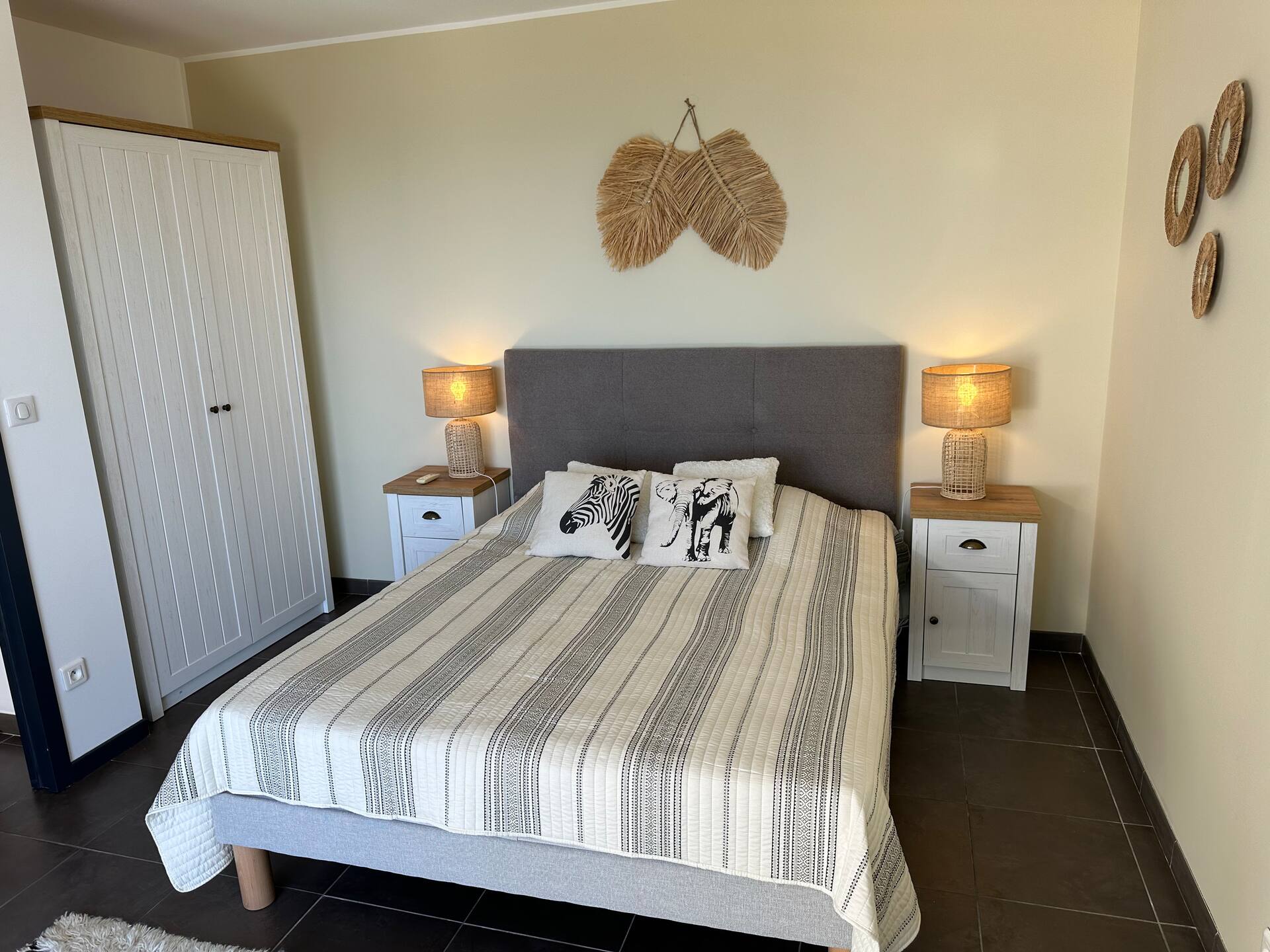 Chambre double à la tête de lit capitonnée, armoire et mobilier blancs