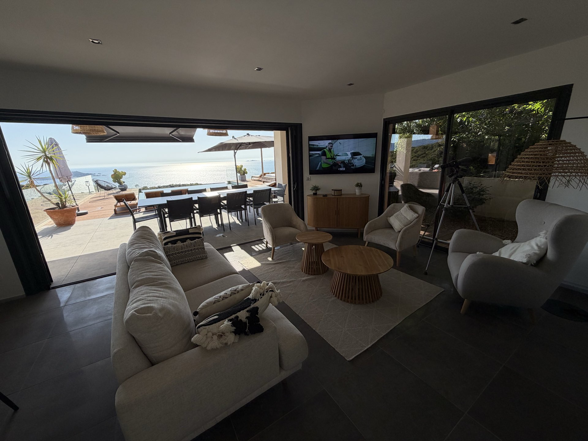 Le canapé du séjour face aux baies grandes ouvertes sur la terrasse et la mer